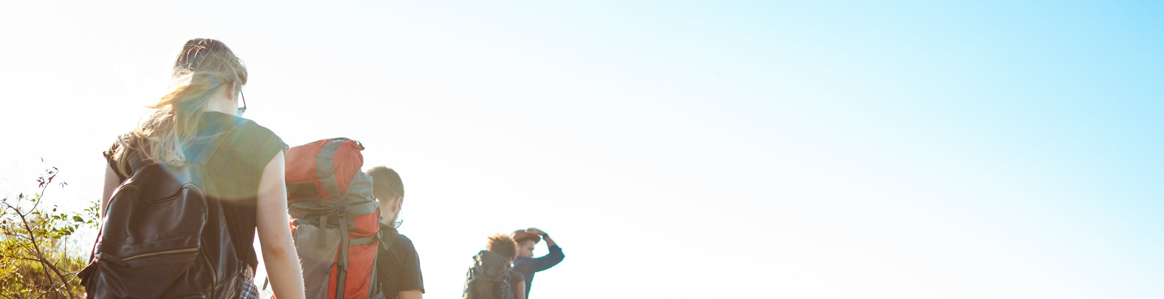 young beautiful friends travelers with backpacks walking canyon